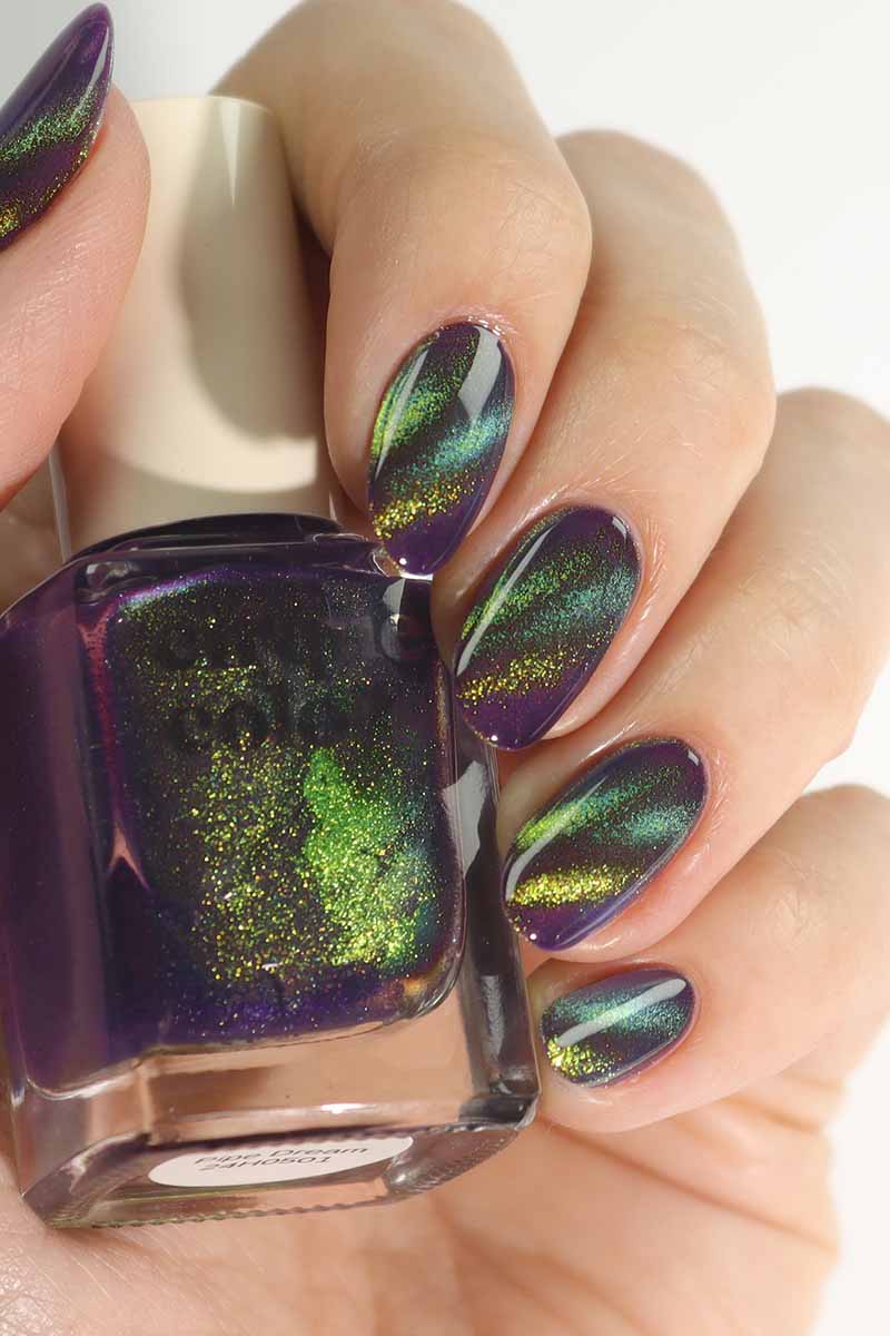 hand model holding bottle of 3D multichrome effect nail polish using Cirque Colors Pipe Dream blurple magnetic polish with green shimmer