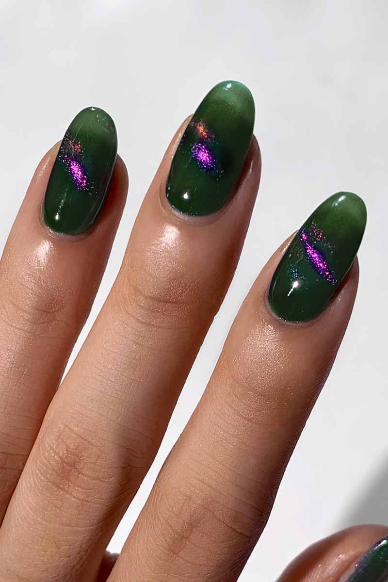 Cirque Colors Folie à Deux forest green magnetic nail polish with 3D magenta, green, gold multichrome pigment on nails